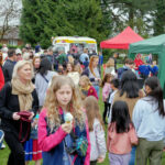 Girl eating ice cream at a busy outdoor fete