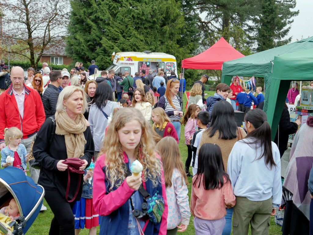 Girl eating ice cream at a busy outdoor fete